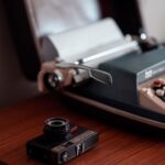 Typemachine, retrocamera en zonnebril op een houten tafel